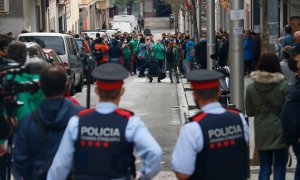 3.	Dos agents dels Mossos d’Esquadra, d’esquena, miren cap als membres de la PAH concentrats per evitar un desnonament previst al carrer Borràs, a Nou Barris, el 4 de noviembre de 2020.