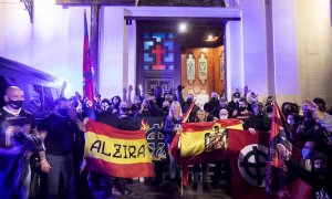 Varios ultraderechistas sostienen una bandera franquista en el acceso a la Iglesia de Benimaclet, el pasado 12 de octubre.