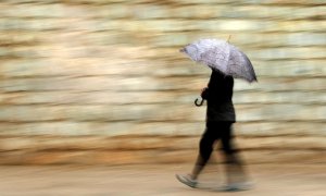 Una persona se protege de la lluvia con paraguas.