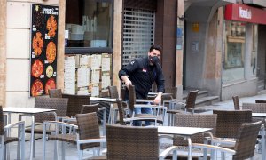 Un camarero prepara la terraza de un bar de Salamanca. Castilla y León ha abierto este viernes las terrazas de la hostelería, salvo en la capital burgalesa.