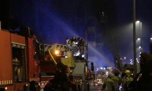 Efectius dels Bombers treballant en les tasques d'extinció de l'incendi en una nau abandonada i ocupada a Badalona la nit del 10 de desembre del 2020.