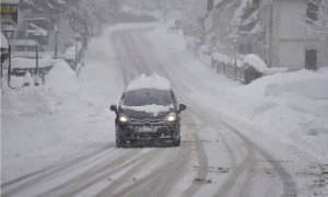 Un coche circula por una carretera en el Pirineo aragonés, en Huesca, Aragón (España), a 29 de diciembre de 2020. La alerta roja por nieve tras la borrasca Bella se mantiene este martes en 14 carreteras del Pirineo aragonés, donde es obligatorio el uso de