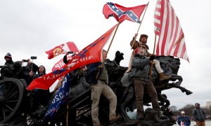 Manifestantes pro-Trump ondean pancartas durante los enfrentamientos con la policía del Capitolio.