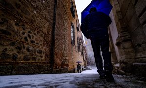 Dos ciudadanos pasean durante una nevada este jueves en Toledo. La borrasca Filomena dejará este jueves copiosas nevadas en zonas del centro y este peninsular, con cotas bastante bajas y espesores de más de 10 centímetros en el este de Castilla-La Mancha,