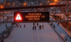 Varios ciudadanos caminan y juegan con la nieve en mitad de la M-30 de Madrid.