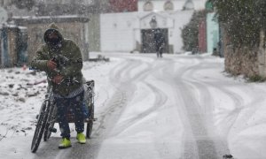 Un hombre con una bicicleta entre la nieve en la Cañada Real el pasado viernes.