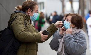 Una mujer ayuda a otra a colocarse la mascarilla este martes en Barcelona.