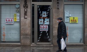 Un hombre camina junto a un bar cerrado en Xinzo de Limia, Ourense.