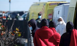 Un grupo de migrantes es atendido tras conseguir llegar en patera al muelle de Caleta de Fuste, en el municipio de Antigua (Fuerteventura).