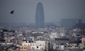 La torre Glòries de Barcelona tras una nube densa de contaminación.