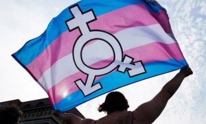 Una persona ondea una bandera trans.