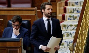 El líder del PP, Pablo Casado, se dirige a la tribuna del Congreso y pasa por el lado del exministro de Sanidad, Salvador Illa.