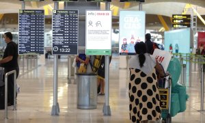 Pasajeros cerca de páneles informativos en la terminal T4 del aeropuerto Adolfo Suárez Madrid-Barajas, en Madrid. E.P./Jesús Hellín