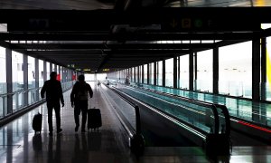 Dos pasajeros cruzan una de las terminales del Aeropuerto Adolfo Suárez Madrid-Barajas.