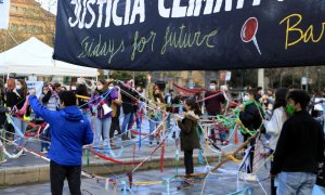 Fridays For Future Barcelona prepara una performance amb una xarxa en el dia d'Acció Global pel Clima, a Arc de Triomf, per denunciar que el sistema actual els "roba" el temps davant de l'emergència climàtica. 19 de març del 2021.