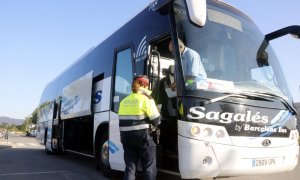 Un Mosso controla la documentació d'un bus.