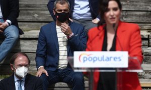 Toni Cantó observa a la presidenta de la Comunidad de Madrid, Isabel Díaz Ayuso, durante la presentación de la candidatura del PP de Madrid para las elecciones a la Asamblea de Madrid en el Auditorio del Parque Lineal del Manzanares, en Madrid (España) a