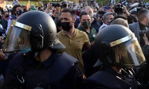 El líder de Vox, Santiago Abascal, rodeado por la Policía a su llegada al mitin del partido de ultraderecha en Vallecas, Madrid.