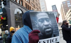 Un manifestante sostiene una pancarta de George Floyd en una protesta reclamando justicia en Mineápolis (EEUU)