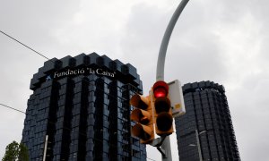 Un semáforo en rojo delante de los edificios centrales de Caixabank en Barcelona. REUTERS/Nacho Doce