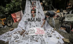 24/04/2021. Una mujer prepara una pancarta con retratos tachados de miembros de la junta militar en protesta contra el golpe de Estado en Myanmar. - Reuters