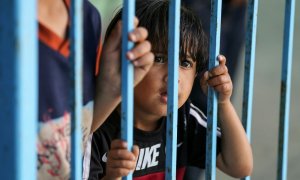 Un niño palestino, que huyó de su casa con su familia debido a los ataques aéreos y de artillería israelíes, mira a través de una barandilla en una escuela dirigida por las Naciones Unidas donde se refugian, en Gaza.