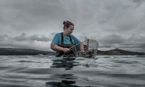 Una mariscadora coge almejas en el mar. Raimon Moreno