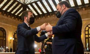 El nuevo presidente de la Generalitat, Pere Aragonès (i) es felicitado por del presidente de ERC, Oriol Junqueras (d) tras ser elegido por mayoría absoluta en la segunda jornada del debate de investidura celebrado en el Parlament este viernes.