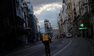 Un repartidor circula en bicicleta por la Gran Vía de Madrid, que permanece prácticamente sin coches debido a la crisis del coronavirus. Reuters/Susana Vera