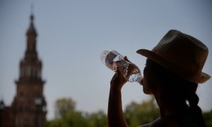 Una mujer bebe agua en Sevilla durante la ola de calor de junio de 2019.