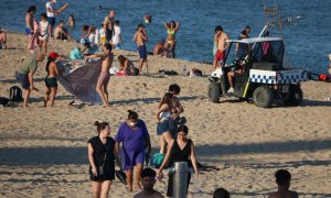 Un vehicle de la Guàrdia Urbana demana als banyistes que abandonin la platja de la Nova Icària, abans de tancar-la aquesta Nit de Sant Joan. 23 de juny de 2020.