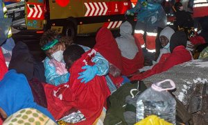 Ocupantes de la embarcación encallada en Órzola, en Lanzarote, con el equipo de emergencia.