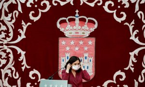 La presidenta madrileña, Isabel Díaz Ayuso, se coloca la mascarilla mientras preside la ceremonia de toma de posesión de los nuevos consejeros de la Comunidad de Madrid, este lunes, en la Real Casa de Correos.