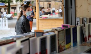 Una mujer con mascarilla en la feria del libro de Oviedo.