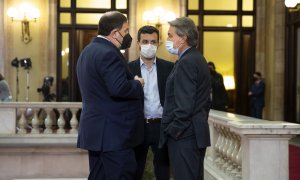 L'expresident Artur Mas i l'exvicepresident Oriol Junqueras, acompanyat d'un col·laborador, xerren abans de la investidura del president de la Generalitat, Pere Aragonès, el 21 de maig de 2021.