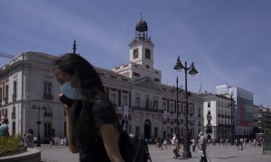 Una mujer con mascarilla en la Puerta del Sol, durante el último día en el que es obligatorio el uso de la mascarilla en exteriores.