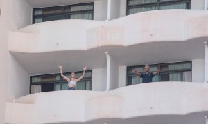 Dos jóvenes que permanecen en aislamiento en el hotel Palma Bellver de Palma saludan desde los balcones de sus habitaciones, este martes 29 de junio en Palma de Mallorca.