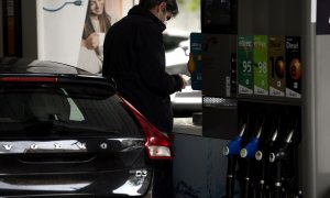 Un hombre echa gasolina a su coche en una gasolinera.