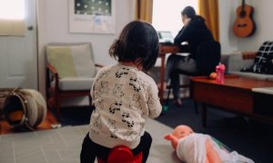 Una niña juega mientras su madre teletrabaja.