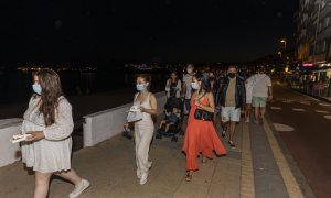 Gente andando por la noche. Foto de archivo.