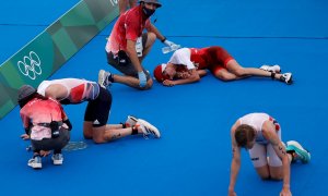 26/07/2021.- Jonathan Brownlee (i) de Gran Bretaña, Max Studer (c) de Suiza y Casper Stornes de Noruega descansan en el suelo tras cruzar la meta del triatlón masculino durante los Juegos Olímpicos 2020, este lunes en el parque marino de Odaiba en Tokio (