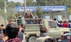 Los talibanes montan guardia frente al aeropuerto internacional Jamid Karzai mientras la gente camina hacia el aeropuerto para huir del país.