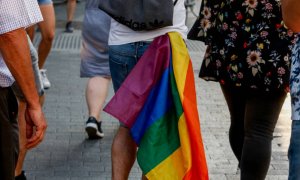 Un joven se cuelga una bandera LTGB