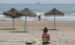 Una mujer toma el sol en una playa de Valencia.