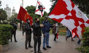 Miembros de la Sociedad Patriotas del Perú desfilan con banderas de la Cruz de Borgoña.