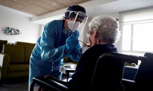 Una cuidadora ayuda a comer a una anciana en una residencia madrileña. EFE/Mariscal