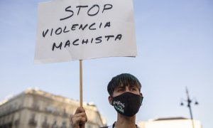 Una mujer sostiene una pancarta en una concentración para exigir un Pacto de Estado Contra la Violencia de Género.