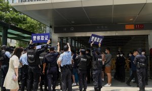 Agentes de la policía tratan de disolver la concentración de inversores y proveedores de la inmobiliaria China Evergrande, frente a su sede en la ciudad de Shenzhen, al sudeste del país, ante el temor de la que la empresa vaya a la quiebra y no les pague.