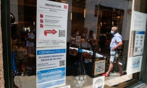 Carteles en diferentes idiomas de indicaciones de obligatoriedad de presentar certificados antes de acceder al interior, en una marisquería de la Rua do Franco, el día en que el TSXG declara nula la petición de certificado Covid para entrar en hostelería,