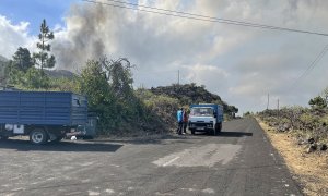 Elena, una veterinaria de la isla, y otros dos hombres hablan con uno de los voluntarios que están sacando animales y pertenencias de las fincas agropecuarias de El Paso.